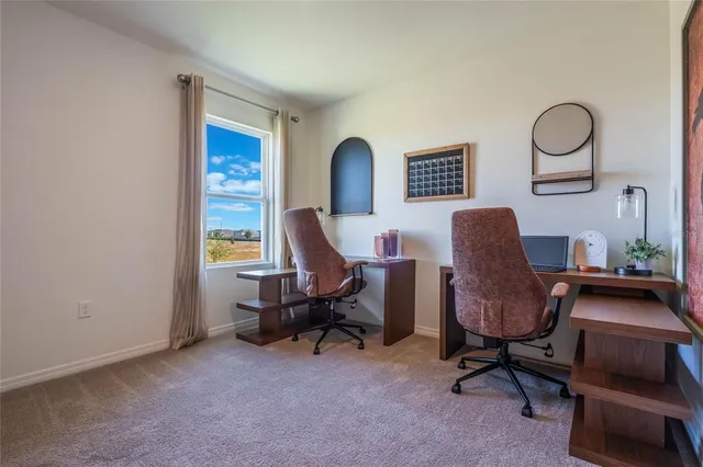 a view of a workspace with furniture and a window