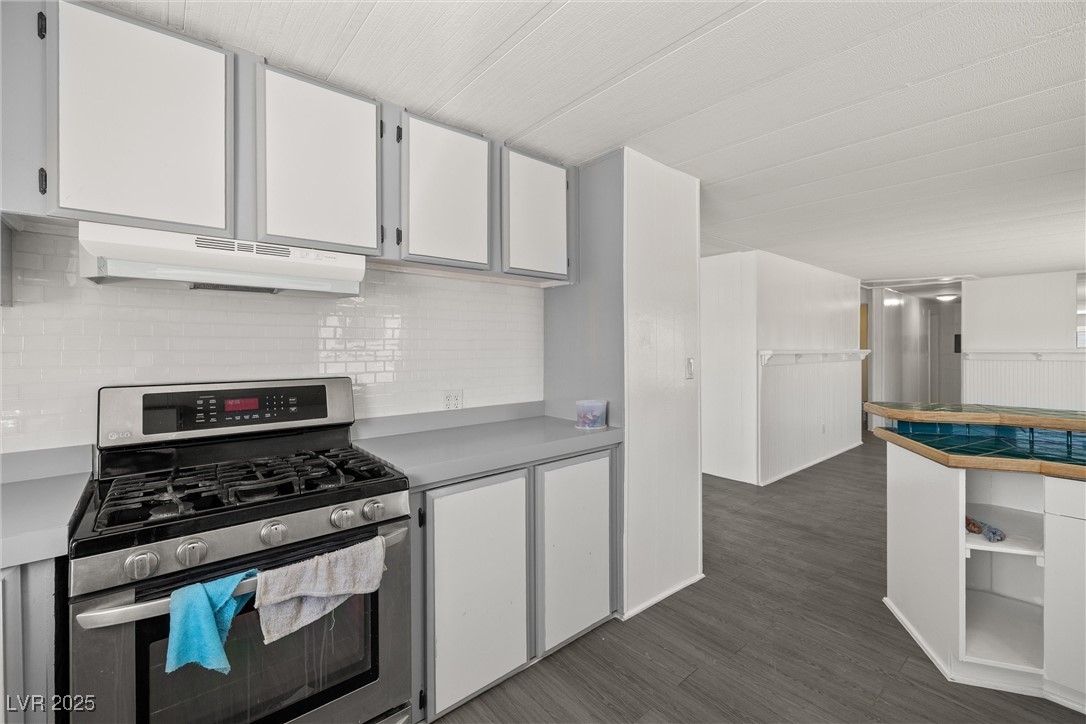 2150 West Harris Farm Road Pahrump, NV 89060 - Photo 16 of 33 Kitchen featuring stainless steel range with gas cooktop, under cabinet range hood, white cabinets