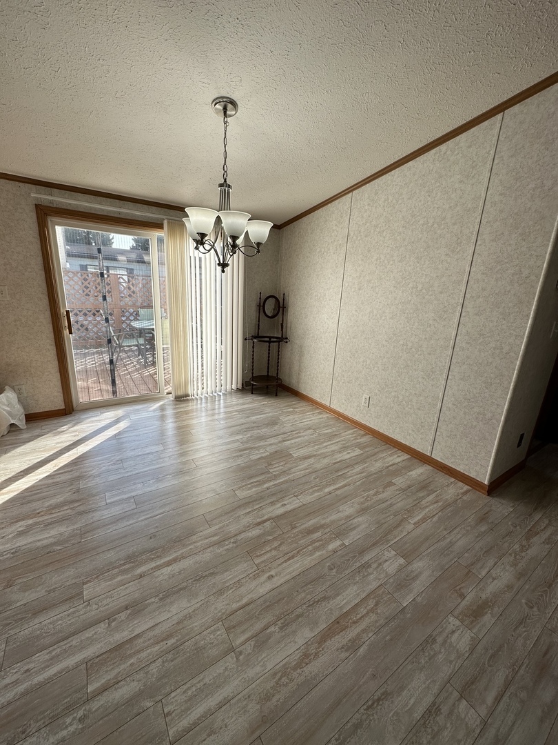 286 Blackthorn Road Matteson, IL 60443 - Photo 9 of 28 an empty room with wooden floor fan and windows