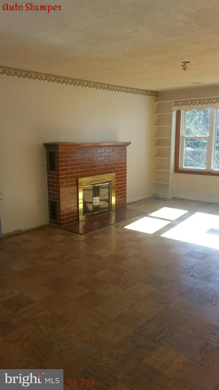 8611 Inwood Road Baltimore, MD 21244 - Photo 9 of 23 a view of an empty room with a fireplace and a window