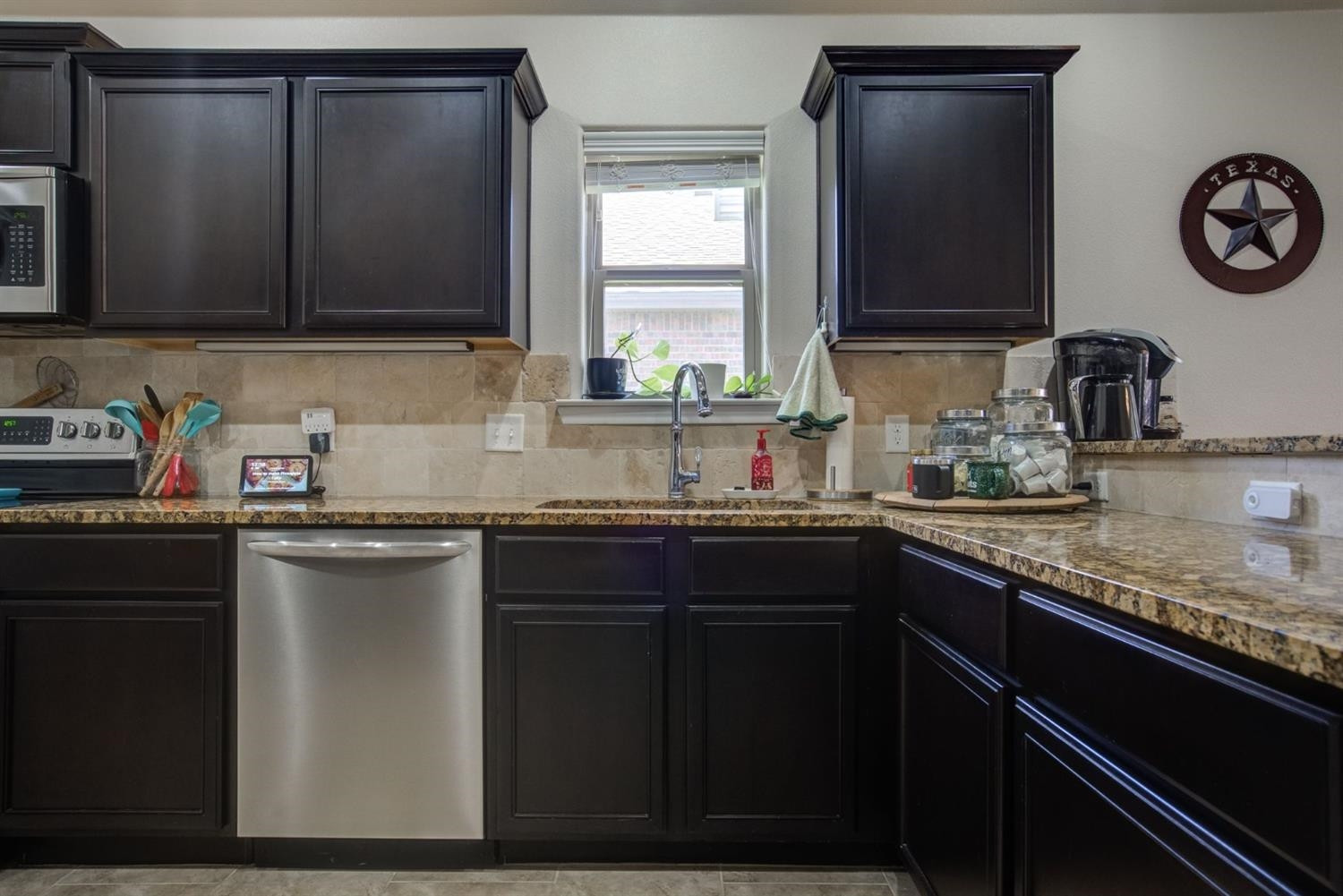 3642 Ridgely Avenue Lubbock, TX 79407 - Photo 8 of 20 a kitchen with granite countertop a sink a stove and cabinets