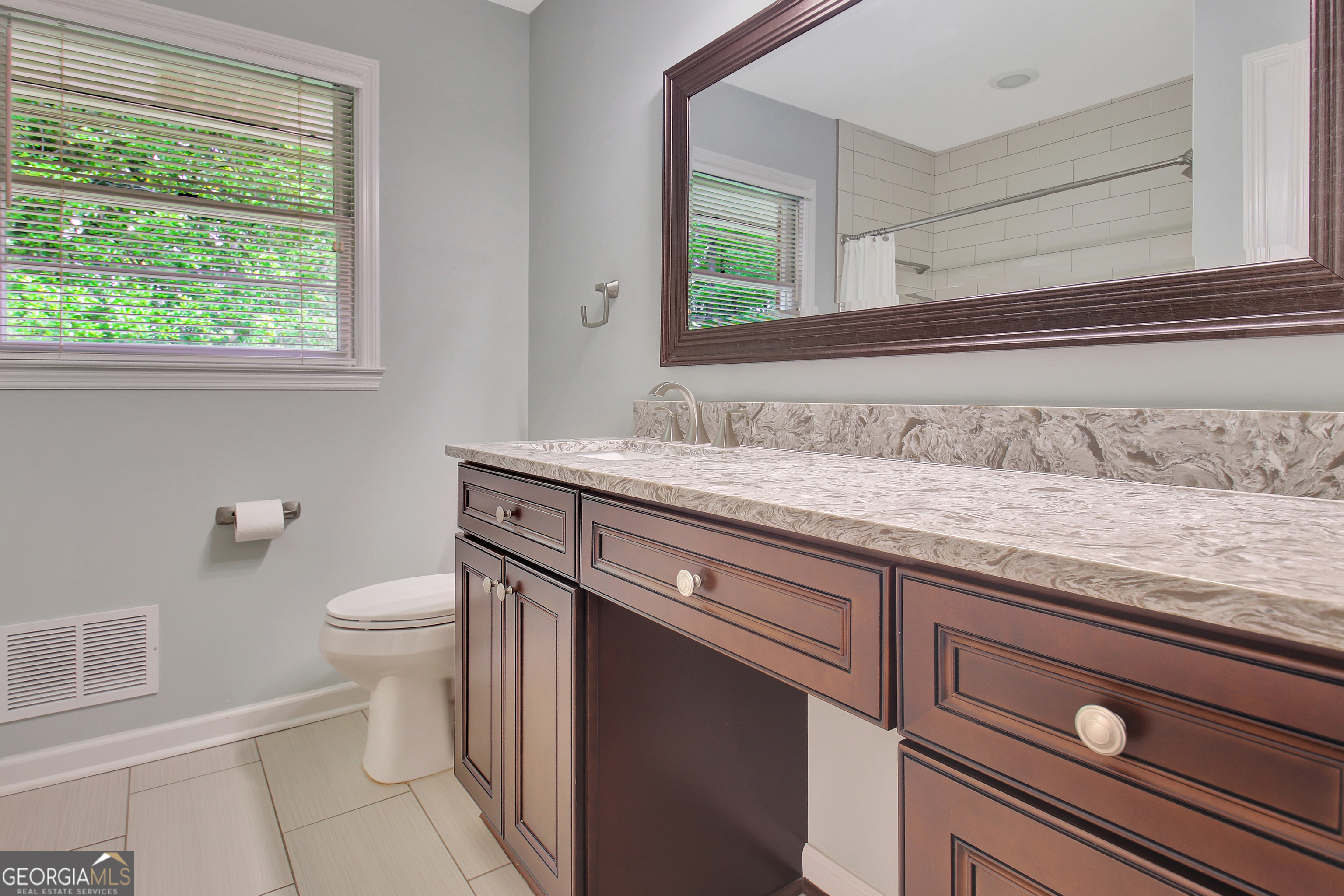 717 Tyrone Road Tyrone, GA 30290 - Photo 25 of 58 a bathroom with a granite countertop sink a toilet and a window