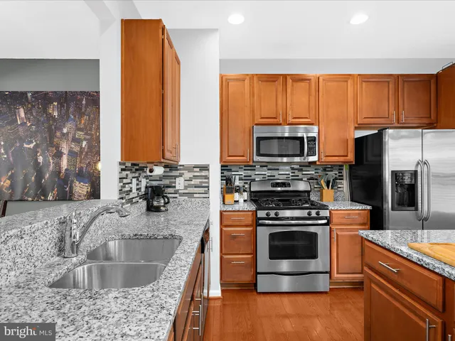 a kitchen with stainless steel appliances granite countertop a stove a sink and a microwave
