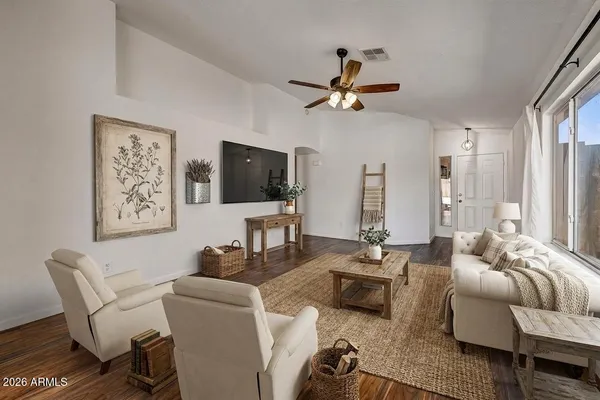 a living room with furniture a flat screen tv and a window
