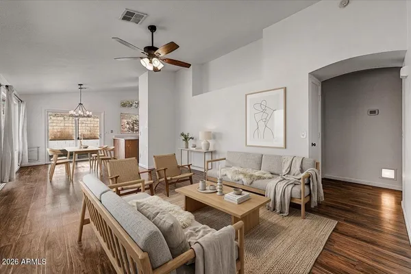 a living room with furniture and a wooden floor