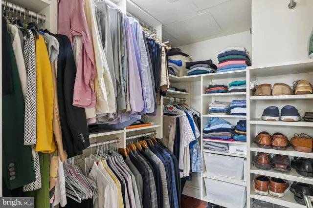 a view of walk in closet with clothes and shoes