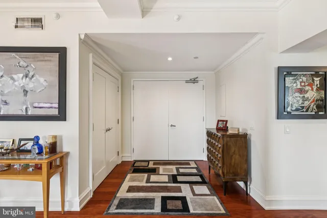 a walk in closet and wooden floor