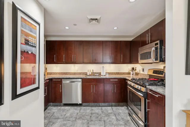 a kitchen with stainless steel appliances granite countertop a stove sink and cabinets