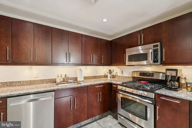a kitchen with stainless steel appliances granite countertop a stove microwave and sink