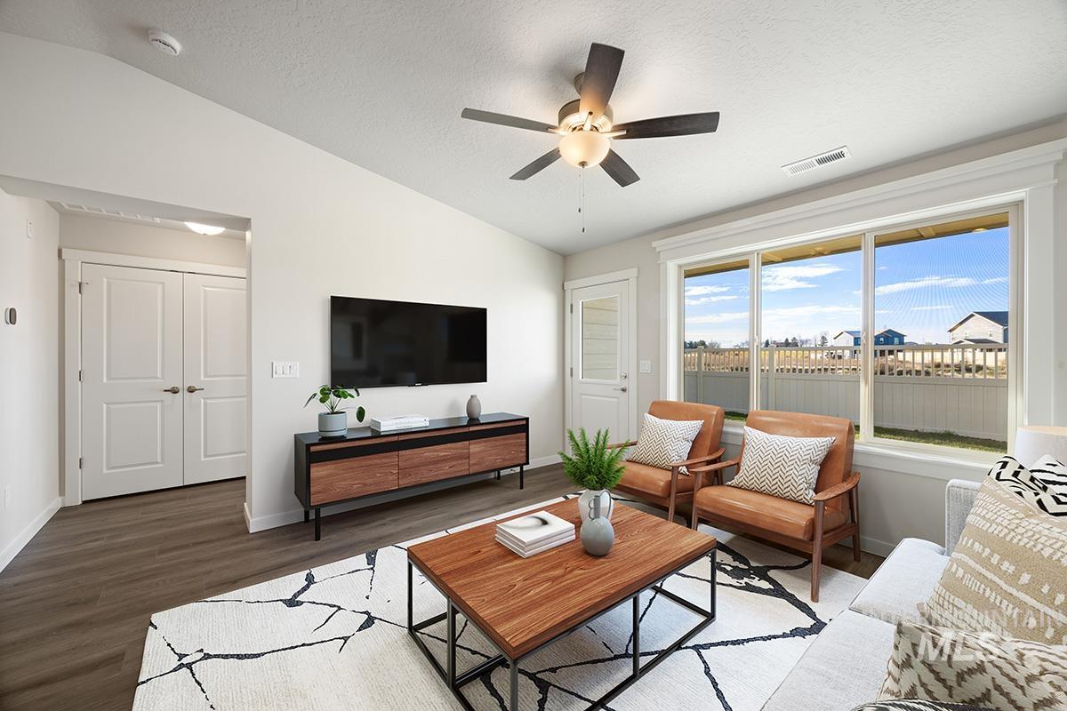 283 West Norwich Street Meridian, ID 83642 - Photo 11 of 25 Living room featuring vaulted ceiling, a textured ceiling, a ceiling fan, and wood finished floors