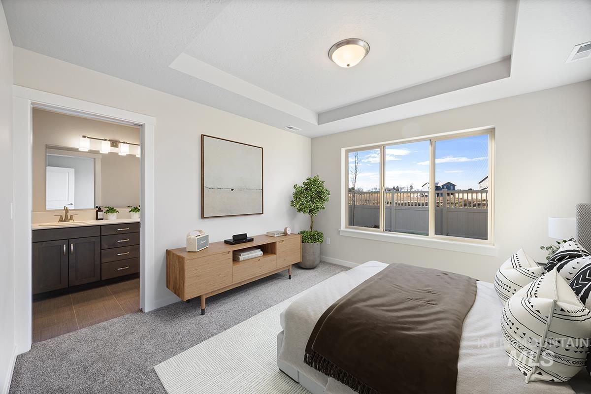 283 West Norwich Street Meridian, ID 83642 - Photo 12 of 25 Carpeted bedroom with a tray ceiling and ensuite bathroom