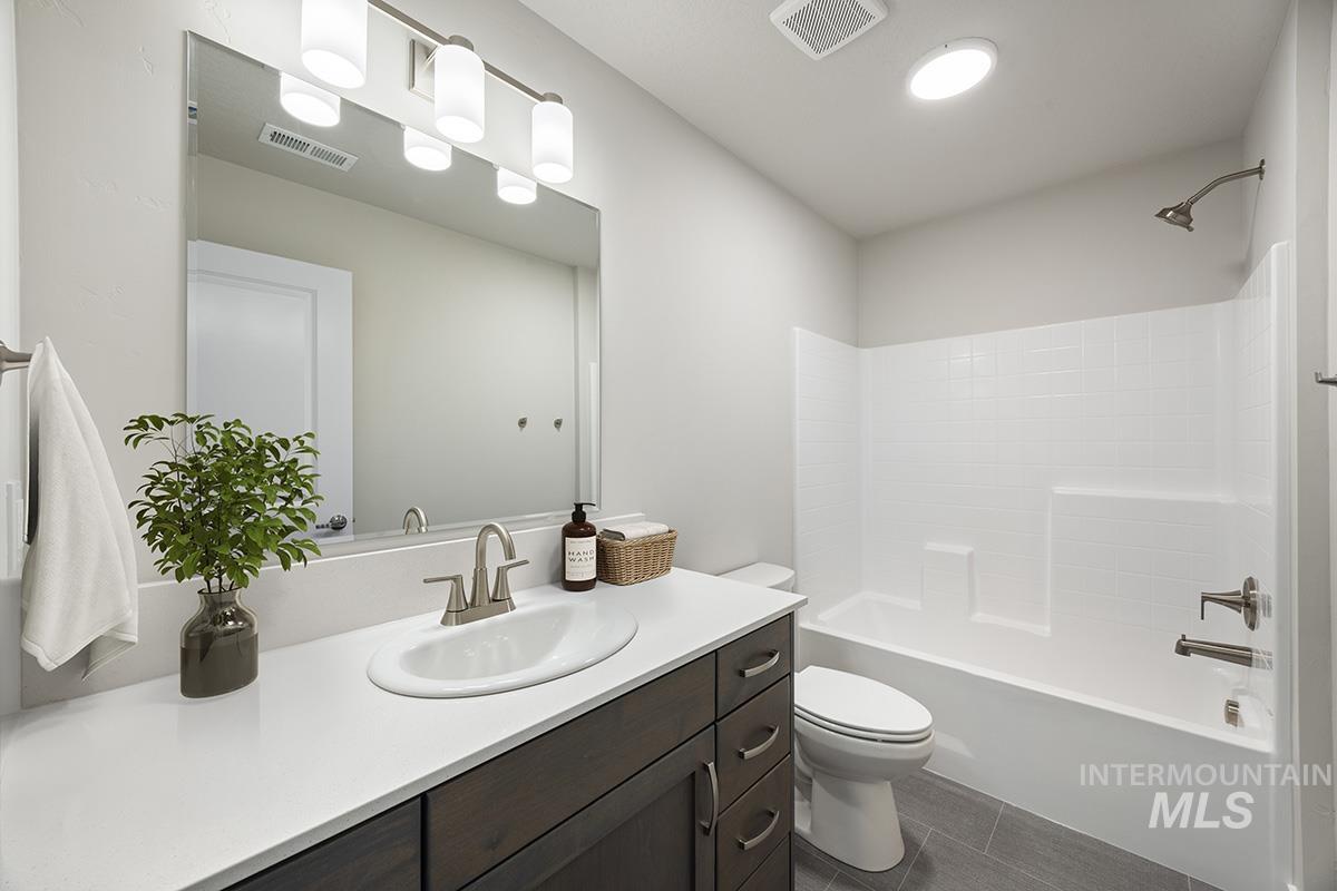 283 West Norwich Street Meridian, ID 83642 - Photo 15 of 25 Bathroom featuring tub / shower combination, vanity, and dark tile patterned flooring
