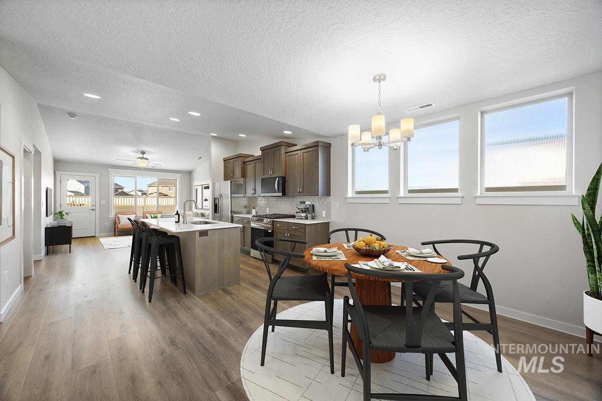 283 West Norwich Street Meridian, ID 83642 - Photo 5 of 25 Dining space featuring a ceiling fan, a textured ceiling, recessed lighting, a chandelier, and light wood-style flooring