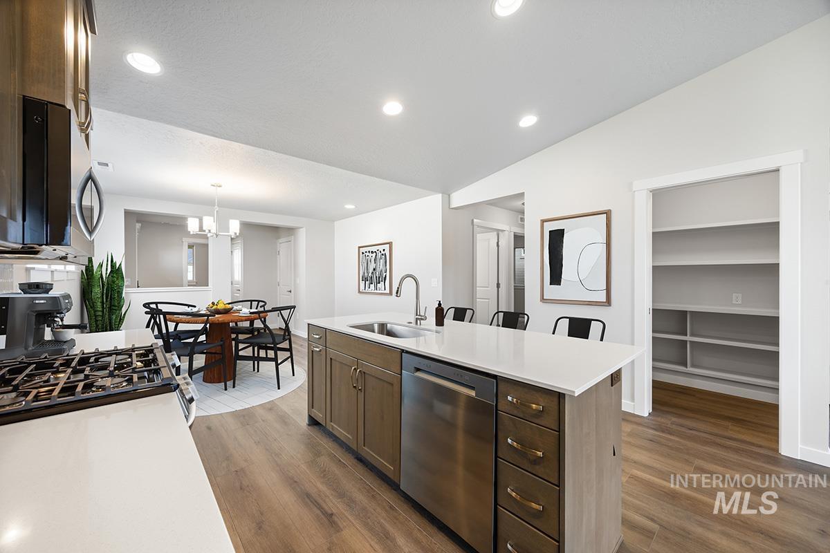 283 West Norwich Street Meridian, ID 83642 - Photo 7 of 25 Kitchen with appliances with stainless steel finishes, dark brown cabinetry, recessed lighting, dark wood-style floors, and decorative light fixtures