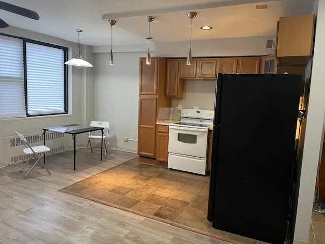 a kitchen with stainless steel appliances kitchen island granite countertop a refrigerator and a stove top oven