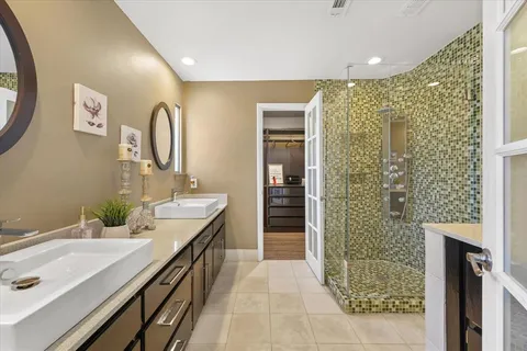 a bathroom with a double vanity sink mirror and shower