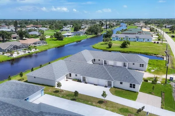 an aerial view of a house with a garden and lake view