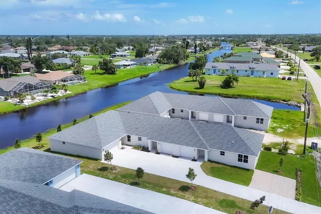 an aerial view of a house with a garden and lake view