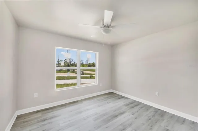 an empty room with a window and ceiling fan