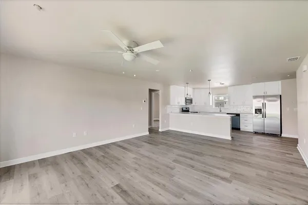 a kitchen with cabinets stainless steel appliances and wooden floor