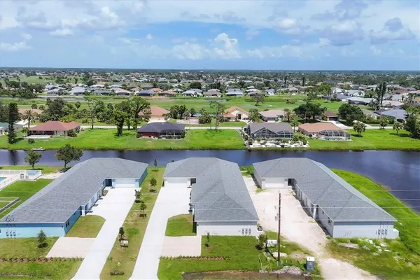 an aerial view of a house with a garden and lake view