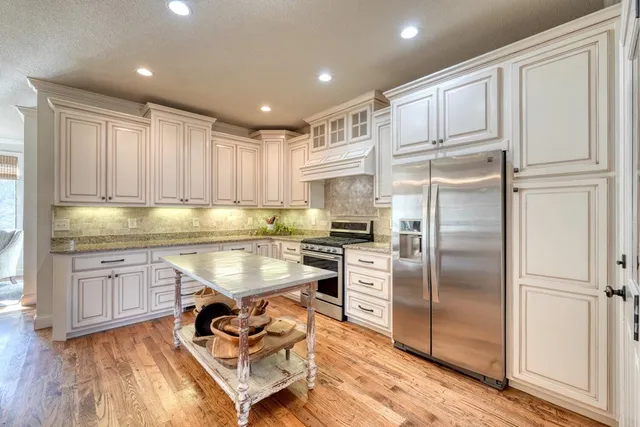 a kitchen with kitchen island granite countertop stainless steel appliances cabinets a sink and a counter top space