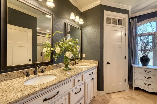 a bathroom with a granite countertop sink a mirror and shower