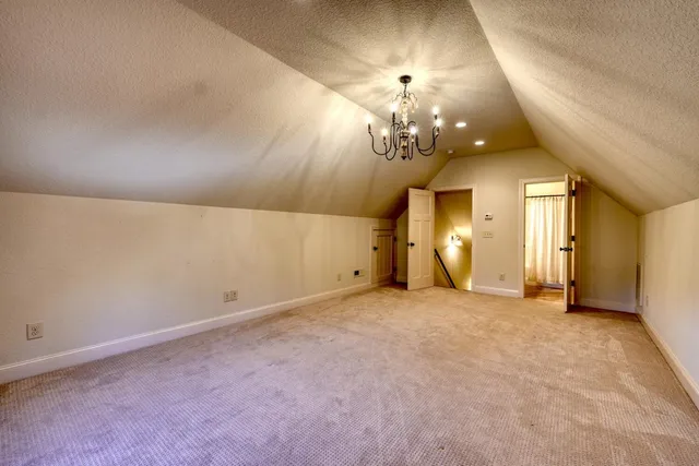 a view of a livingroom with wooden floor a ceiling fan and staircase