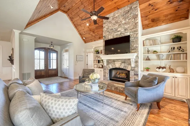 a living room with furniture a flat screen tv and a fireplace