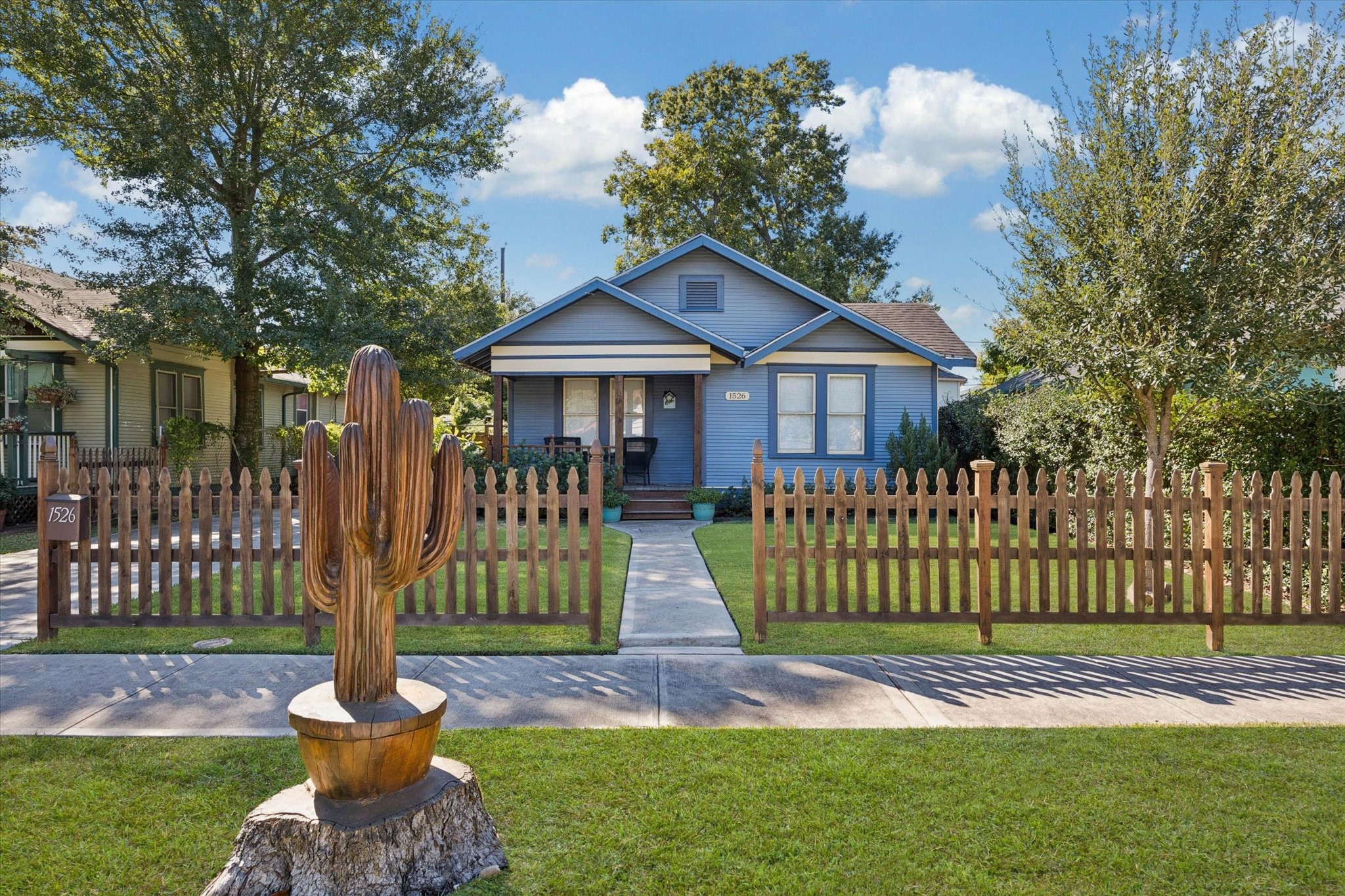 a front view of a house with a garden and trees