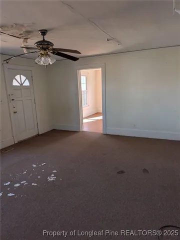 a view of a livingroom with a ceiling fan and window