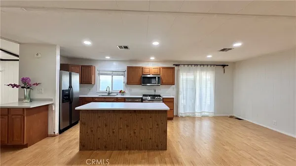 a kitchen with kitchen island a sink stainless steel appliances and cabinets