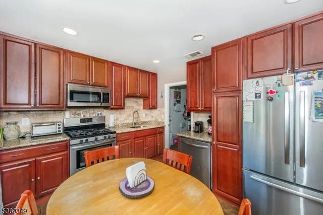 a kitchen with stainless steel appliances granite countertop a refrigerator stove top oven a sink and dishwasher