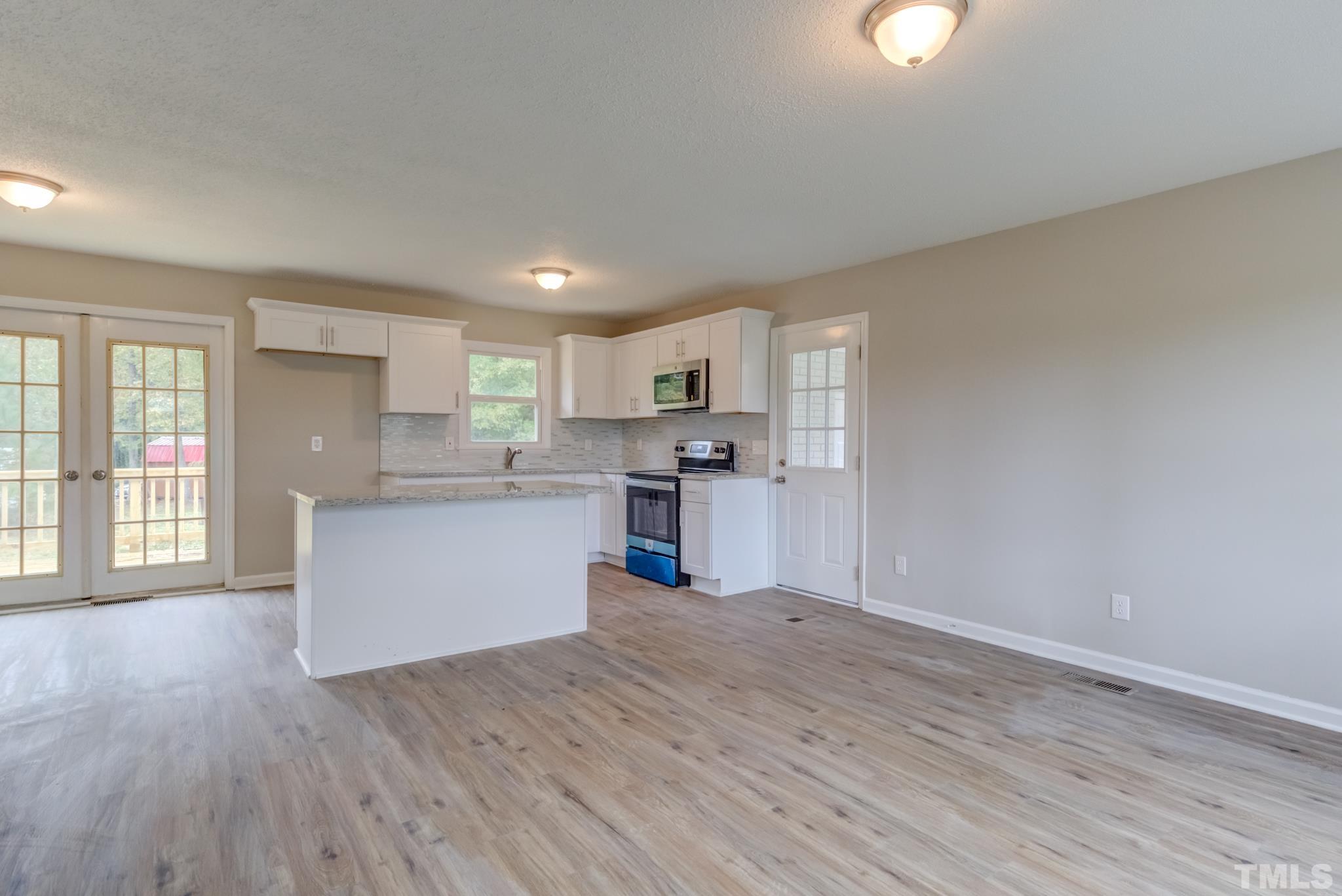 3600 Edgemont Road Wendell, NC 27591 - Photo 13 of 30 a view of a kitchen with stainless steel appliances granite countertop a stove a sink dishwasher and a refrigerator with wooden floor