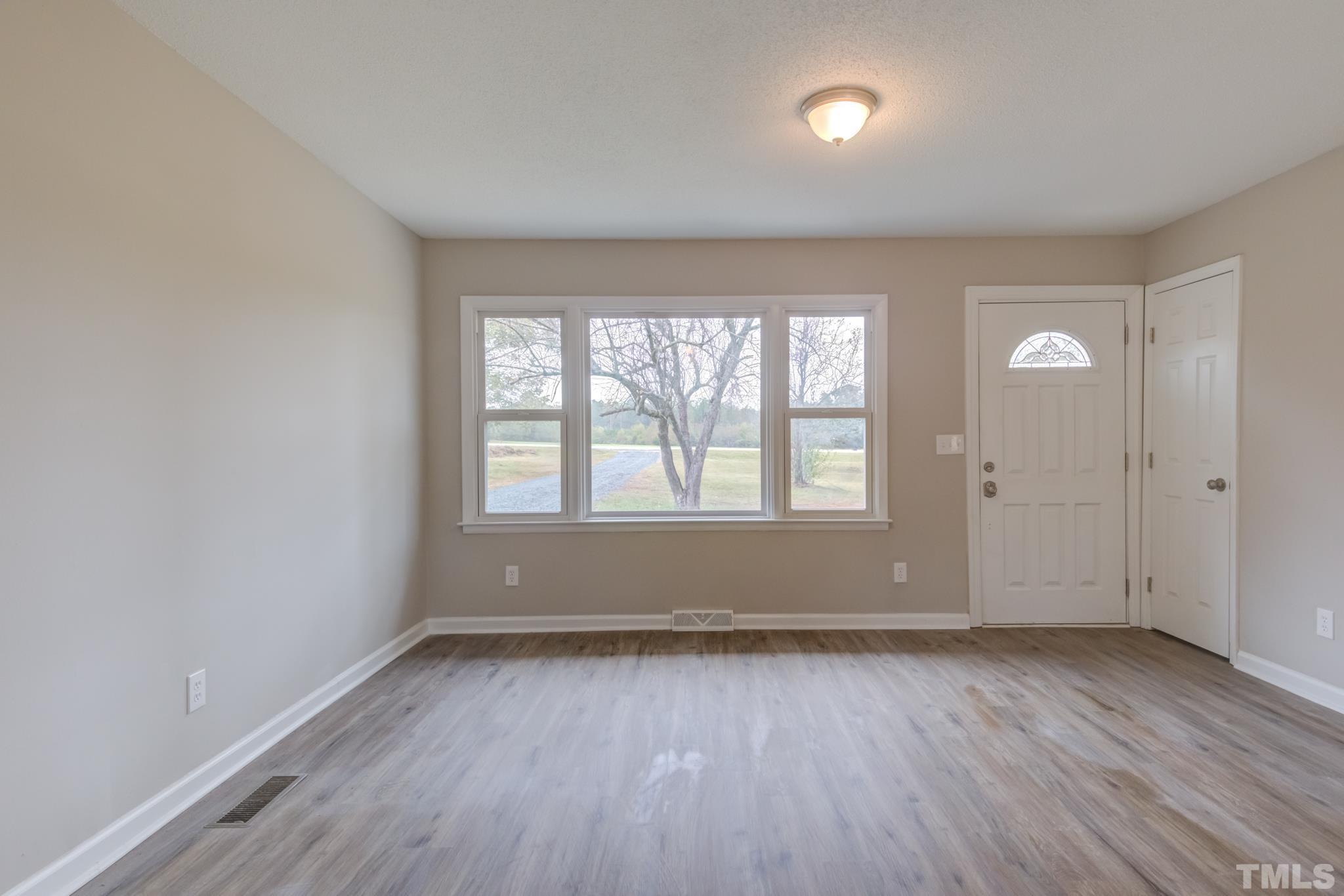3600 Edgemont Road Wendell, NC 27591 - Photo 17 of 30 an empty room with wooden floor and windows