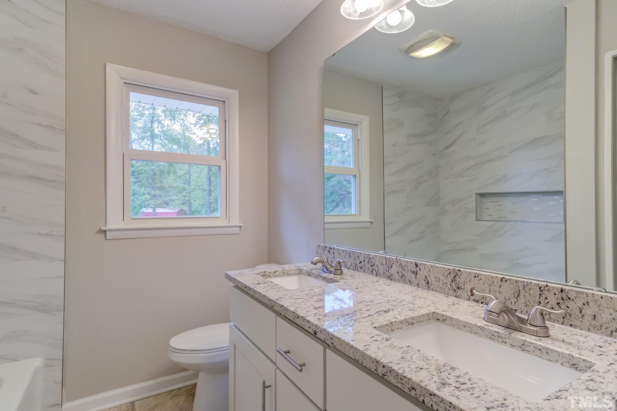 3600 Edgemont Road Wendell, NC 27591 - Photo 20 of 30 a bathroom with a granite countertop sink a toilet and a mirror