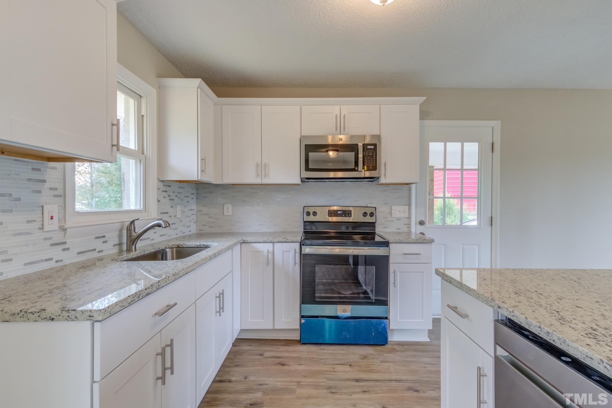 3600 Edgemont Road Wendell, NC 27591 - Photo 10 of 30 a kitchen with stainless steel appliances granite countertop a sink stove microwave and refrigerator