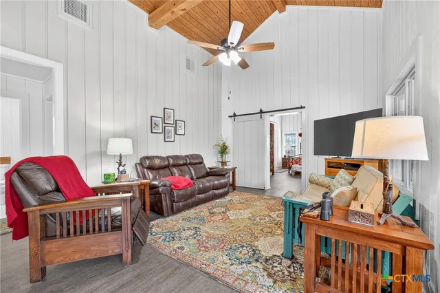 a living room with furniture a couch and paintings on the wall