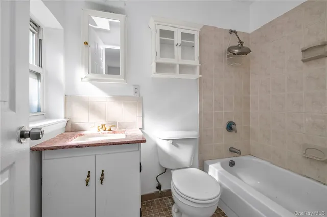 a bathroom with a sink toilet vanity granite shower and bathtub