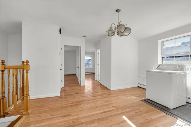 a view of an empty room with wooden floor and windows