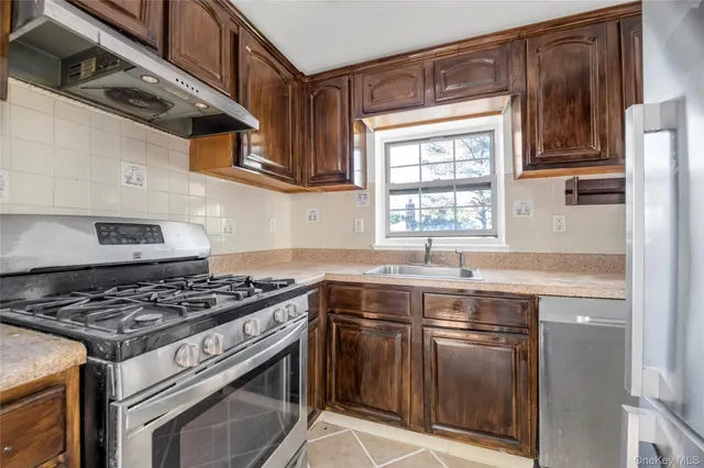 a kitchen with stainless steel appliances granite countertop a sink stove and cabinets