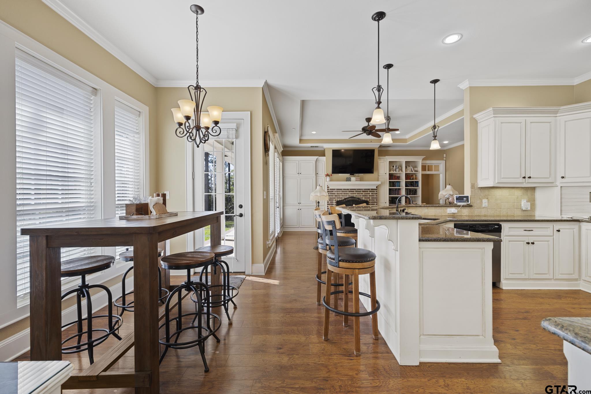 19950 Post Oak Bend Lindale, TX 75771 - Photo 17 of 42 a kitchen with stainless steel appliances kitchen island granite countertop a table chairs and white cabinets