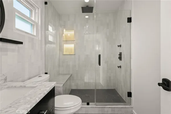 a bathroom with a toilet a sink and a mirror