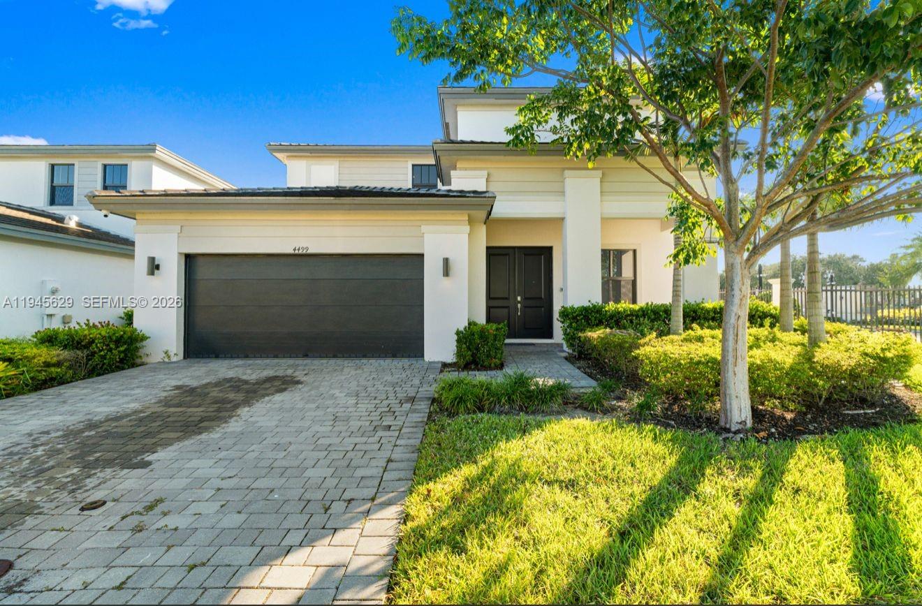 4499 Southwest 173rd Avenue Miramar, FL 33029 - Photo 1 of 11 a front view of a house with a yard and garage