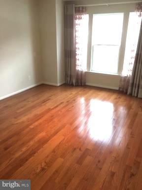 9650 Pullman Place Fairfax, VA 22031 - Photo 8 of 14 an empty room with wooden floor and windows