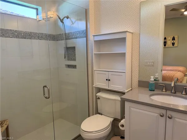 a bathroom with a granite countertop sink toilet and shower