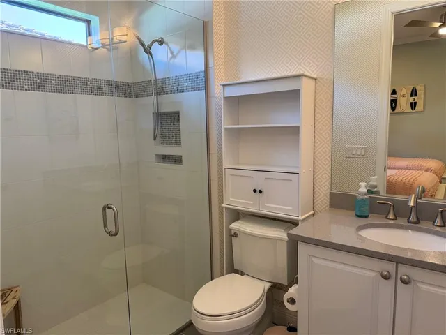 a bathroom with a granite countertop sink toilet and shower