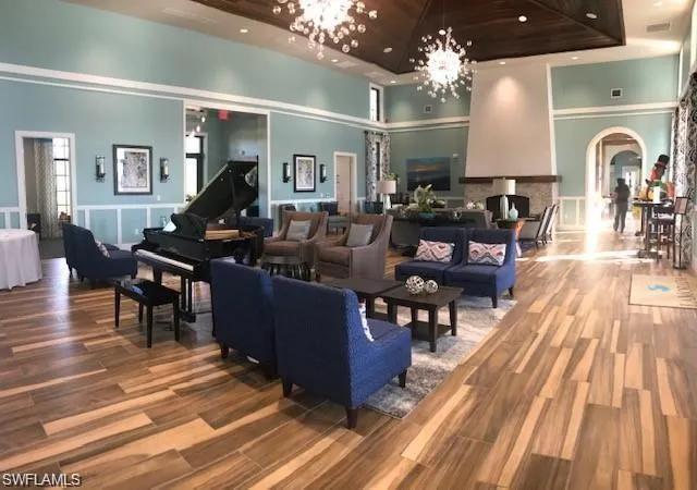 a living room with furniture a chandelier and wooden floor