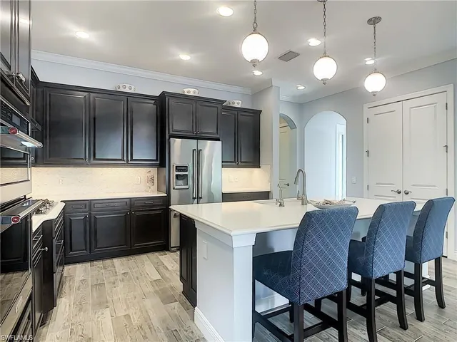 a large kitchen with a table chairs refrigerator and microwave