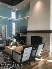 a living room with furniture a fireplace and a dining table with wooden floor